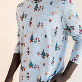 Man showcasing pockets on Men's Jogger Set in Mickey & Friends Christmas print on a beige background