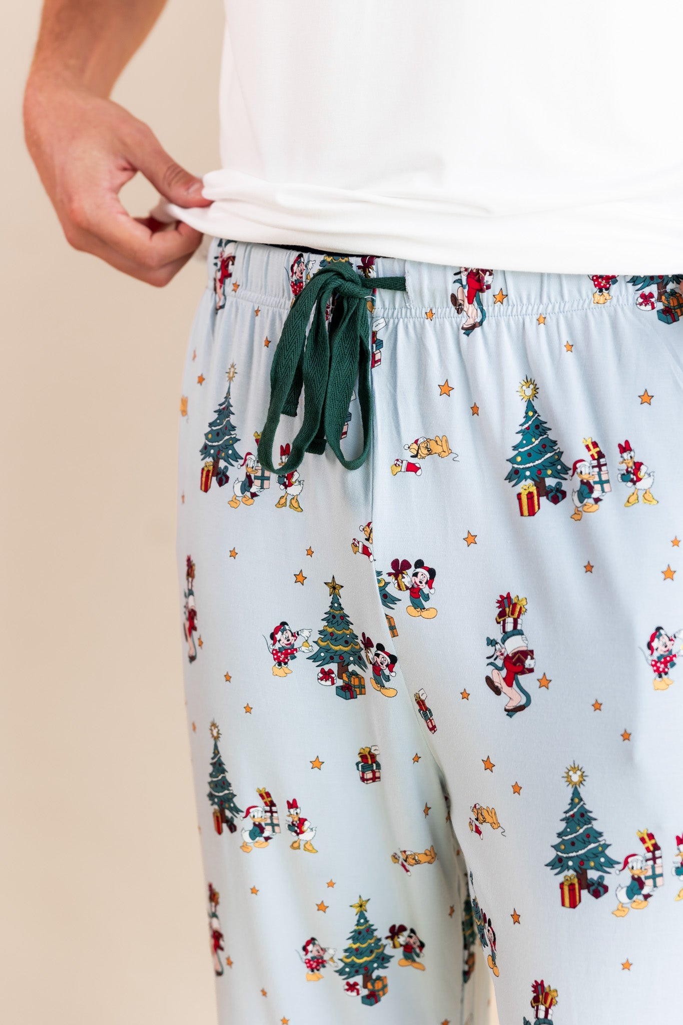 Modal showcasing green drawstring on Men's Lounge Pants in Mickey & Friends Christmas print over white T-shirt on a beige background