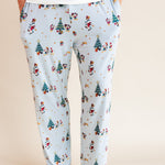 Man wearing Men's Lounge Pants in Mickey & Friends Christmas print with pockets over white T-shirt on a beige background