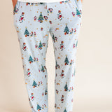 Man wearing Men's Lounge Pants in Mickey & Friends Christmas print with pockets over white T-shirt on a beige background