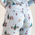 Back side of Woman wearing Women's Jogger Pajama Set in Mickey & Friends Christmas print on a beige background