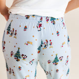 Back side of Modal wearing Women's Lounge Pants in Mickey & Friends Christmas print under white T-shirt on a beige background