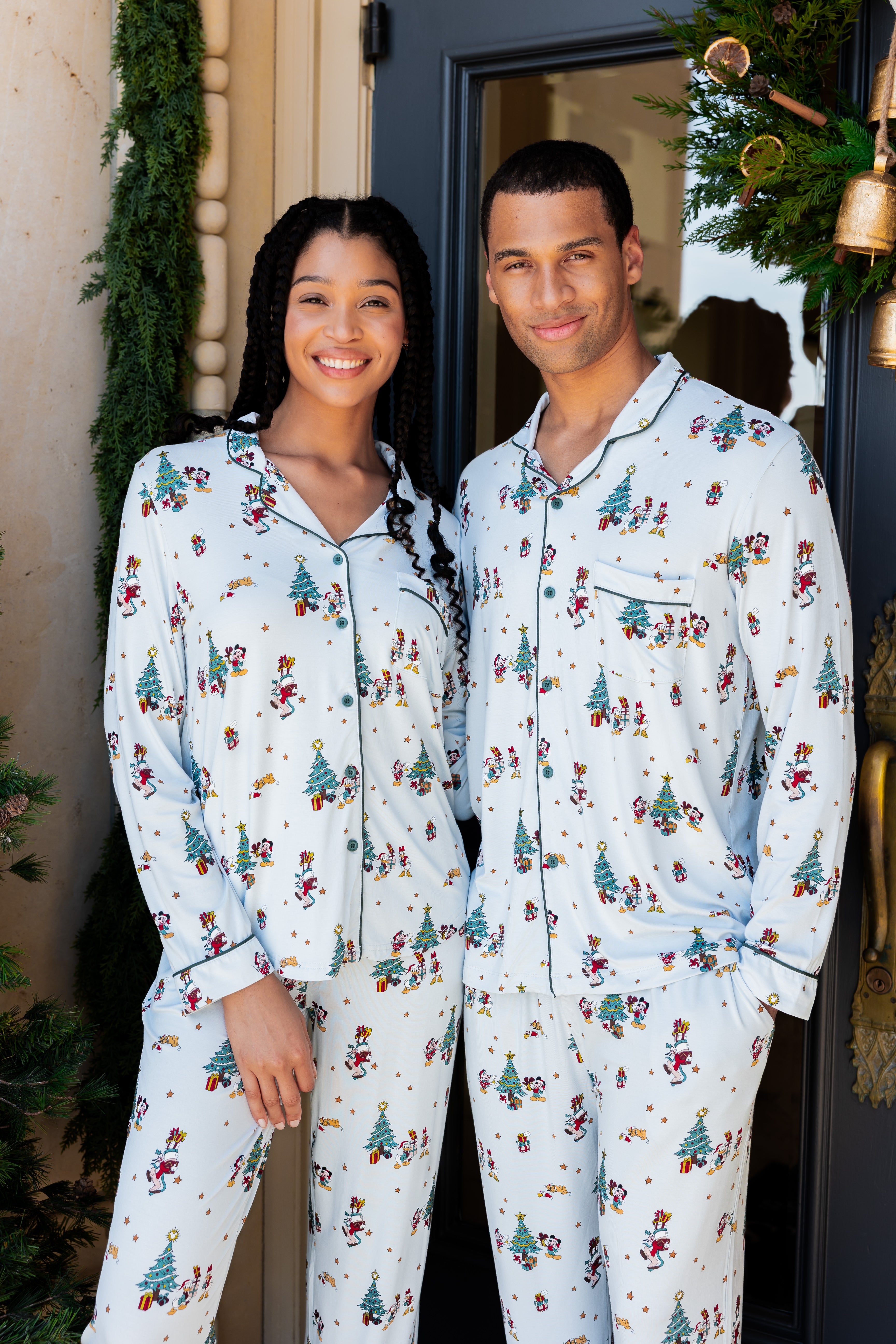 couple wearing matching christmas mickey and friends pajamas