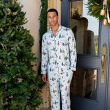 male model wearing holiday mickey printed blue pajama set on a porch decorated with christmas decor