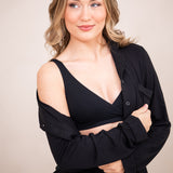 Woman in black cross front bralette with unbottoned pajama top