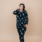 Woman wearing a Big Midnight Magnolia black floral pajama set with hand in pocket 