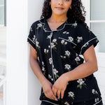 Woman wearing a black floral pajama set against a white background ::: Model is 5'0" wearing size XS ///