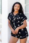 Woman wearing a black floral pajama set against a white background ::: Model is 5'0" wearing size XS ///