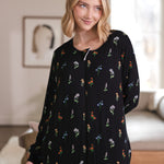 Close up of a model looking to the side with while wearing the Long Sleeve Adult Sleep Bag Walker in Midnight Wildflower