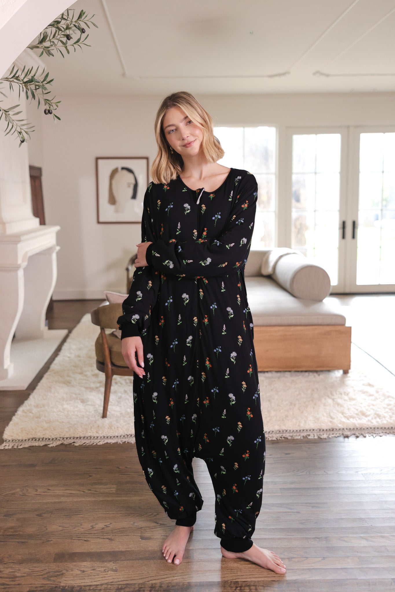 Blonde woman with arms crossed across her front while modeling the Long Sleeve Adult Sleep Bag Walker in Midnight Wildflower 