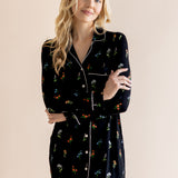 Model smiling in Long Sleeve Women’s Nightshirt in Midnight Wildflower print on a beige background