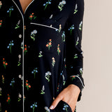 Model showcasing the pockets of Long Sleeve Women’s Nightshirt in Midnight Wildflower print on a beige background