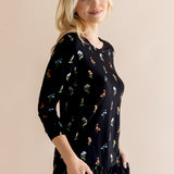 Model posing in Women's Jogger Pajama Set with pockets in Midnight Wildflower print on beige background