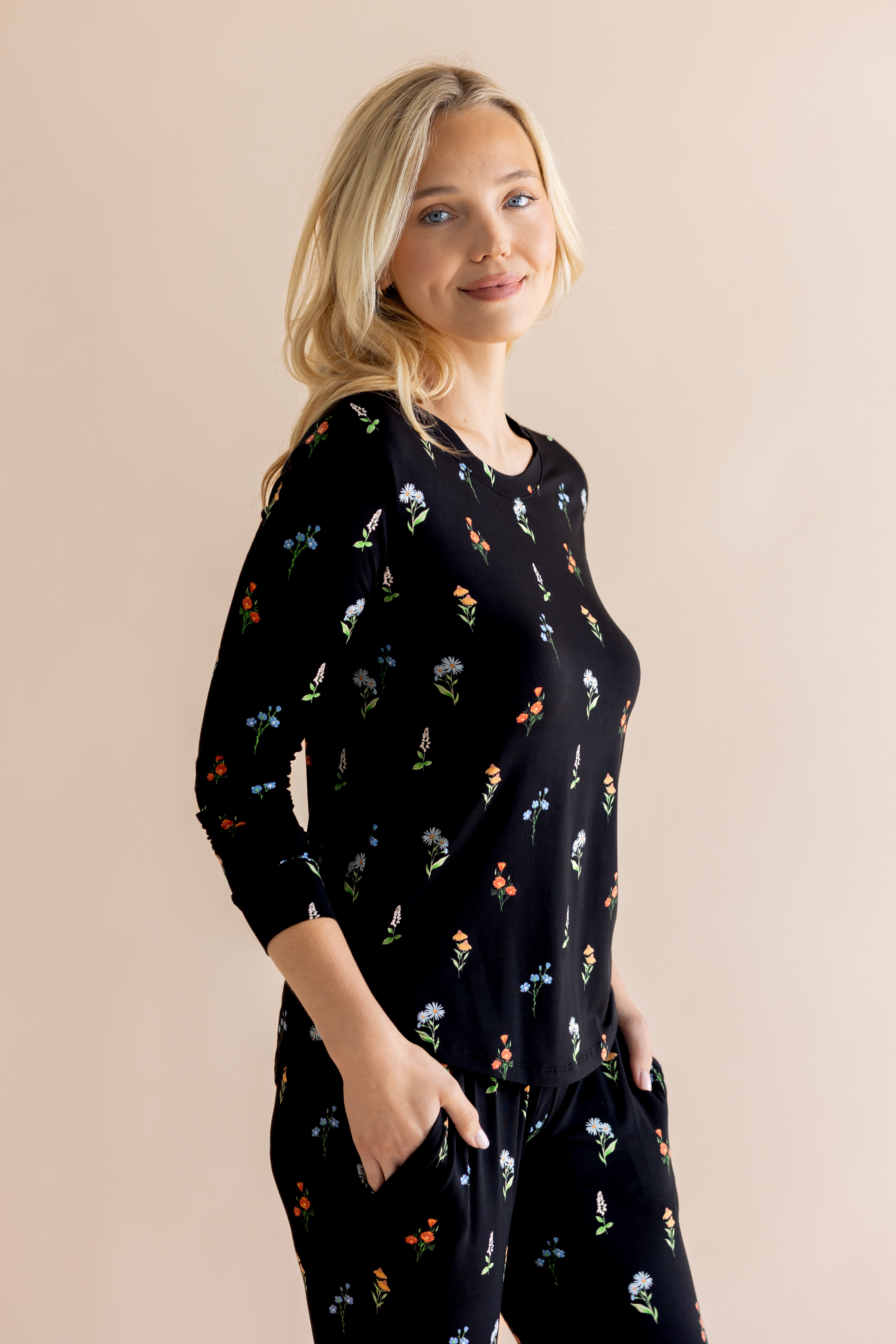 Model posing in Women's Jogger Pajama Set with pockets in Midnight Wildflower print on beige background