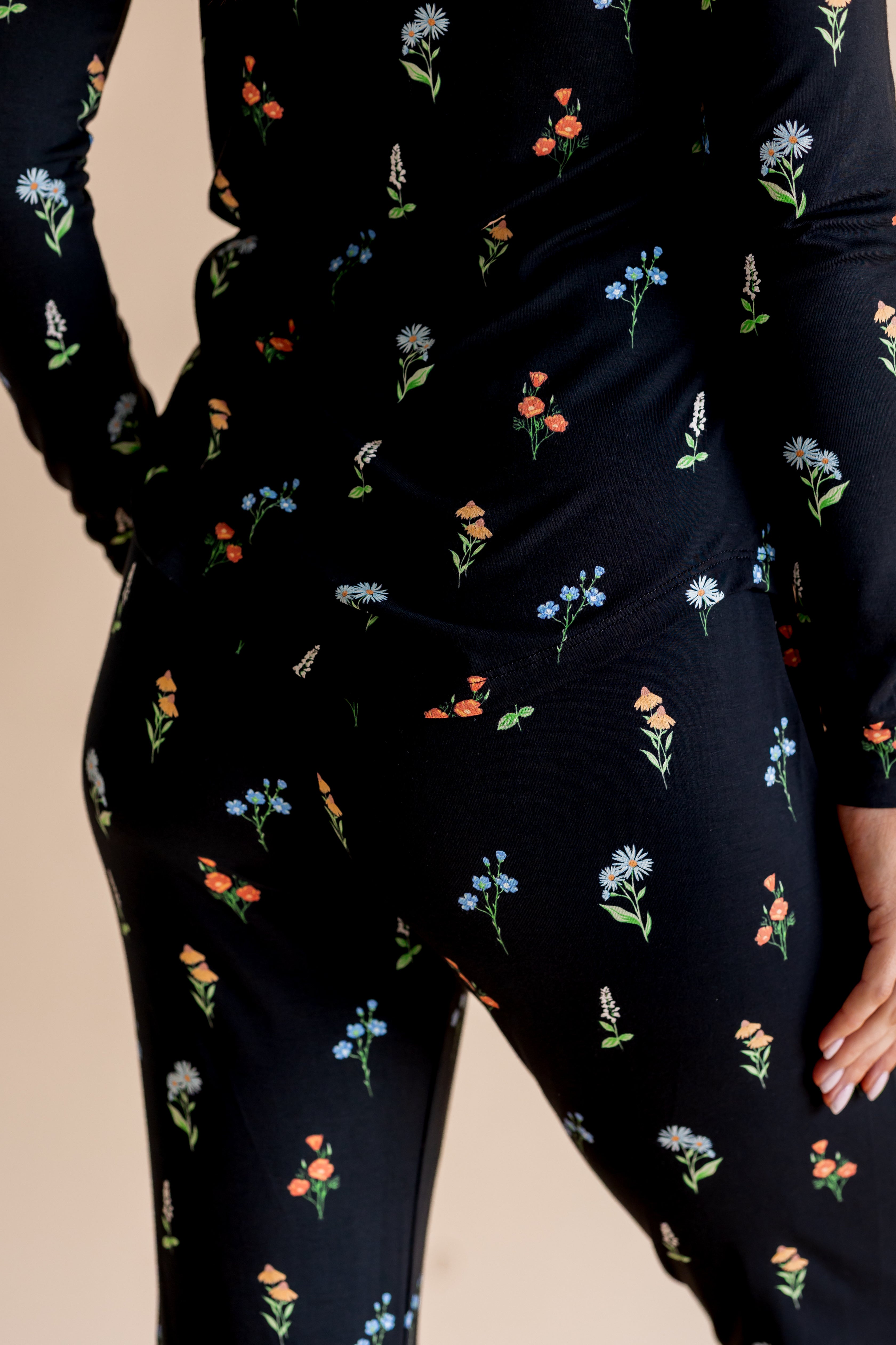 Model showing the back of Women's Jogger Pajama Set in Midnight Wildflower print on beige background