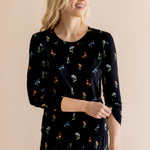 Model smiling in Women's Jogger Pajama Set in Midnight Wildflower print on beige background