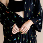 Model wearing Women’s Kimono Robe in Midnight Wildflower print and black bra on a beige background