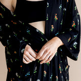 Model wearing Women’s Kimono Robe in Midnight Wildflower print and black bra on a beige background