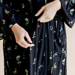 Model showcasing the front of Women’s Kimono Robe in Midnight Wildflower print on a beige background