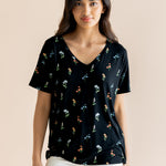 Model wearing Women's Relaxed Fit V-Neck in Midnight Wildflower print over white pants on a beige background ::: Model is 5' wearing size XS ///