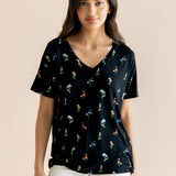 Model wearing Women's Relaxed Fit V-Neck in Midnight Wildflower print over white pants on a beige background ::: Model is 5' wearing size XS ///
