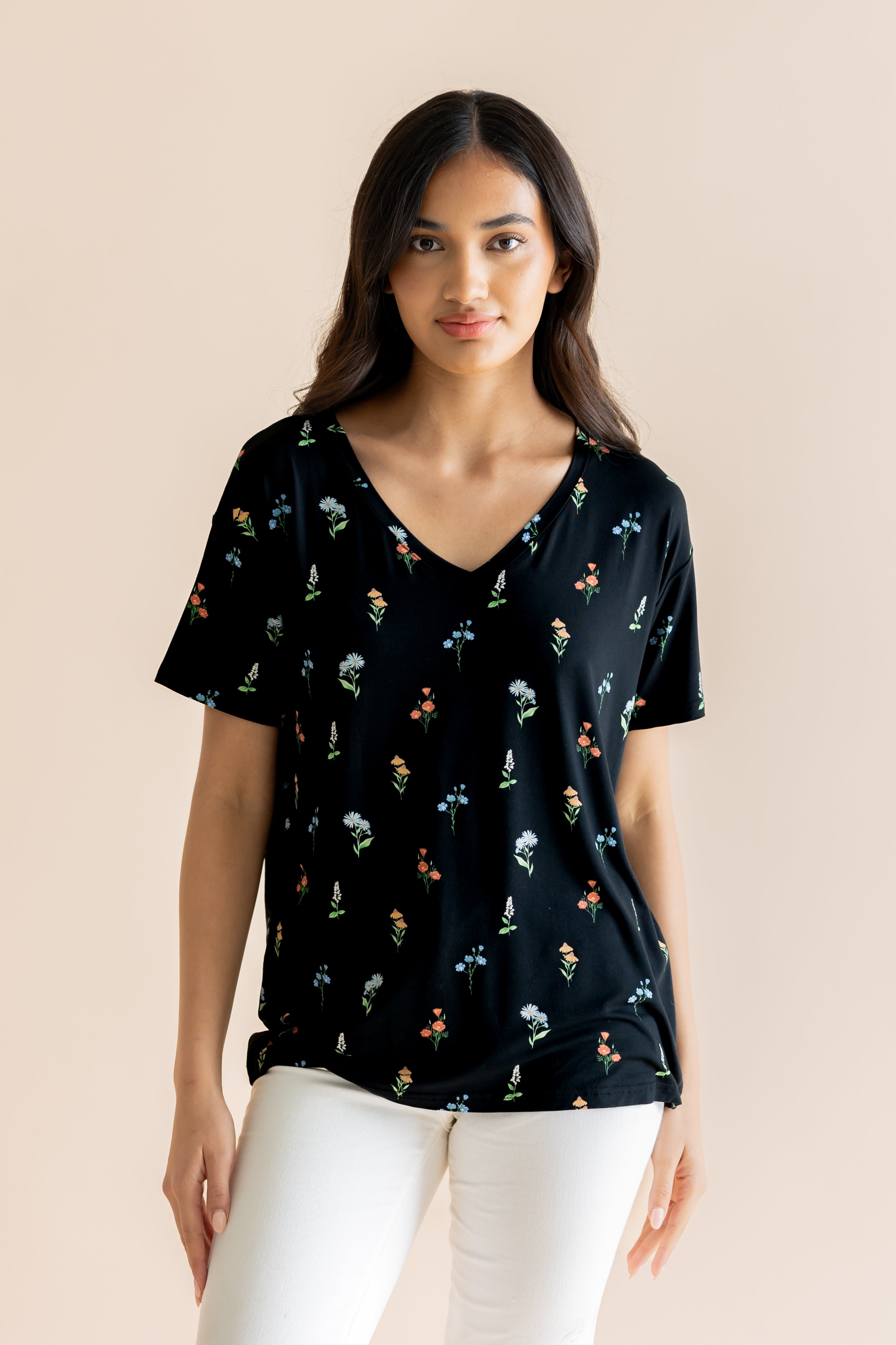 Model wearing Women's Relaxed Fit V-Neck in Midnight Wildflower print over white pants on a beige background ::: Model is 5' wearing size XS ///