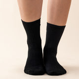 Black socks worn by a person on a beige background