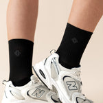 White sneakers with black socks on a beige background