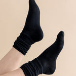 Black socks worn on a beige background