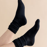 Black socks worn on a beige background