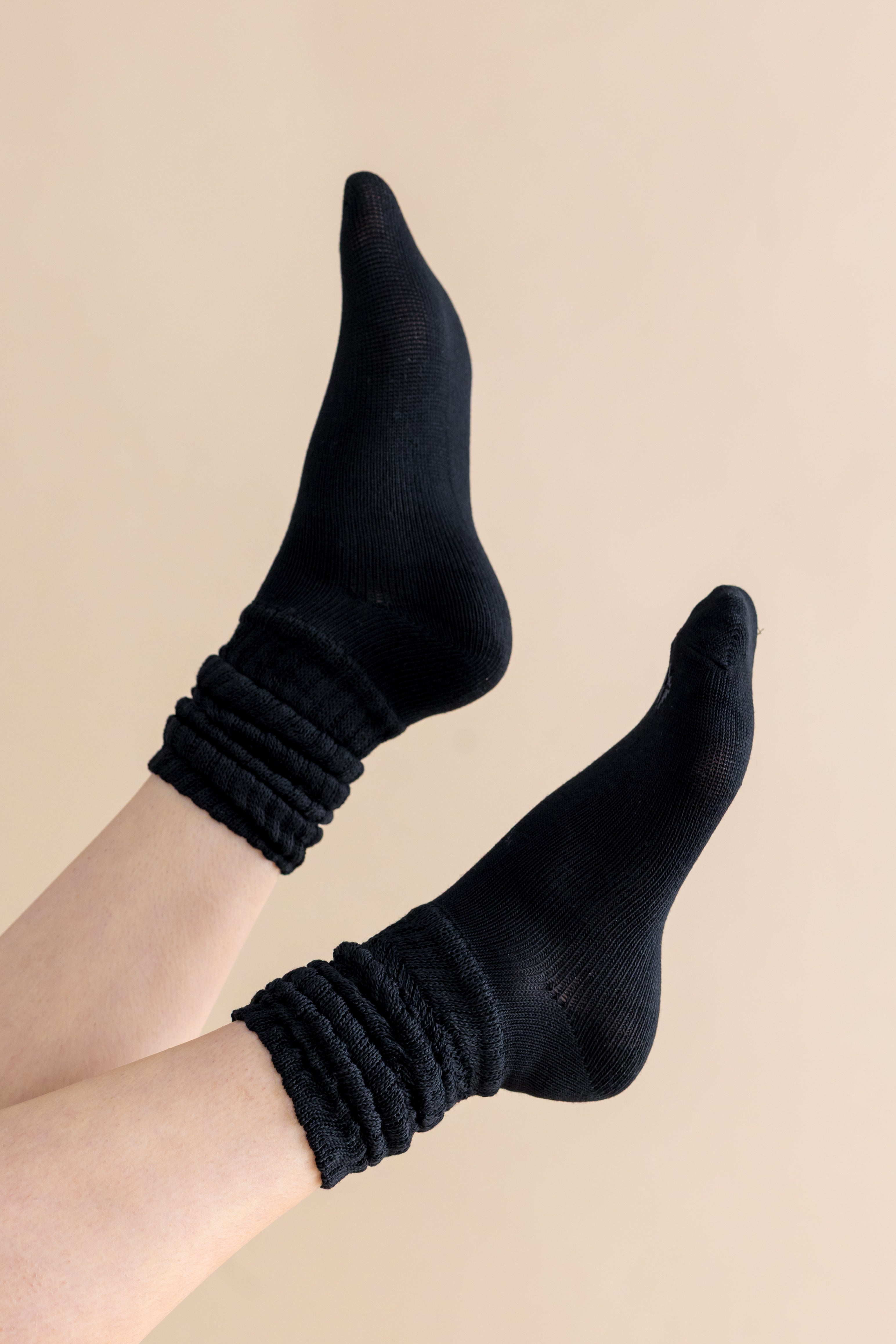 Black socks worn on a beige background