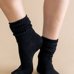 Black socks worn on a beige background