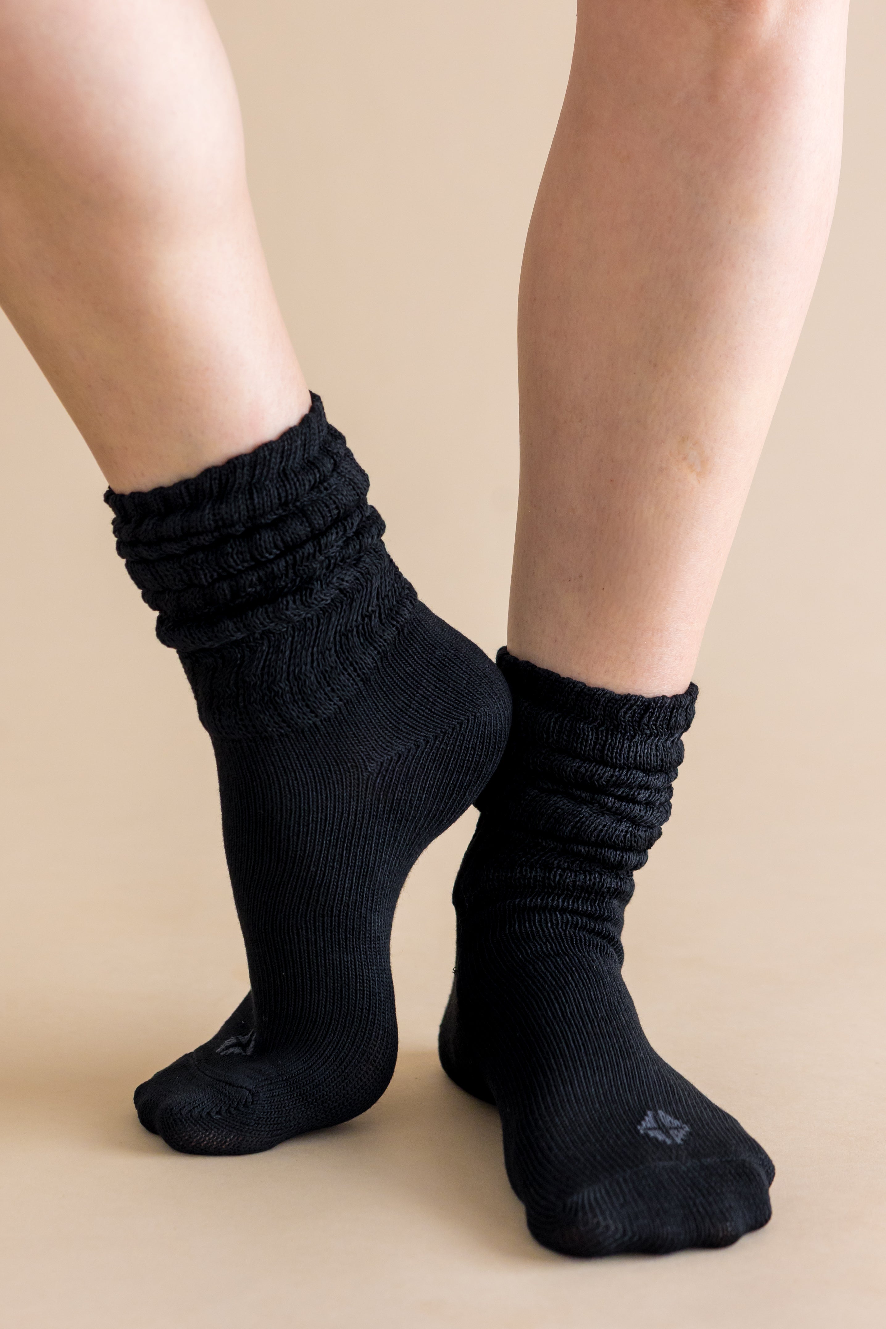 Black socks worn on a beige background