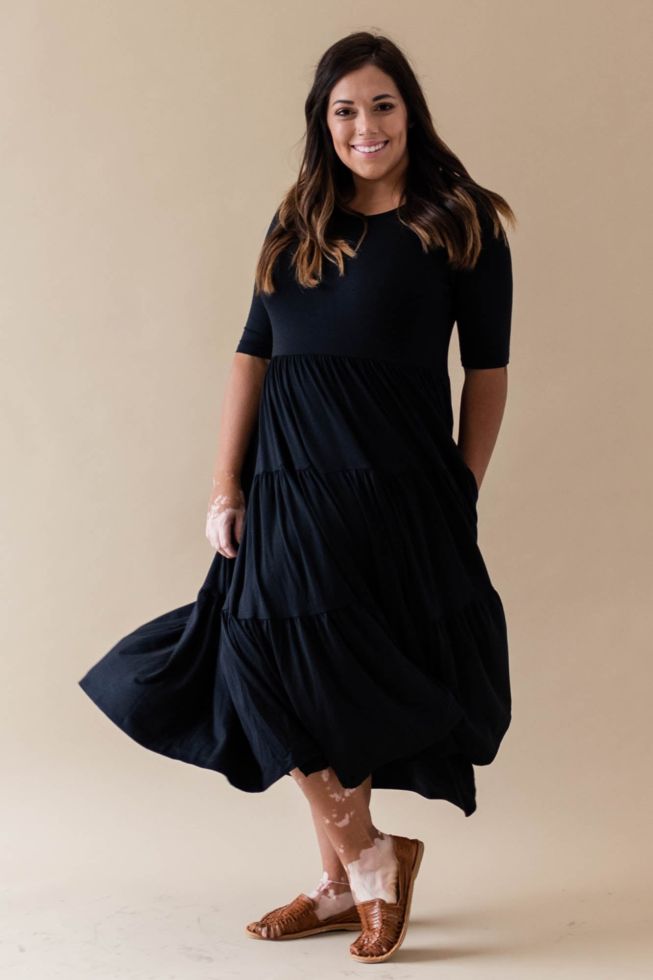 Female model wearing the Women’s Tiered Dress in Midnight with one hand in pocket