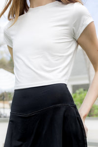 Close up of Bamboo Flex Baby Tee in Cloud while paired with Flex Skort in Midnight