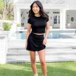 Female model posing in the grass in front of a pool wearing the Bamboo Flex Baby Tee in Midnight with matching skort


::: Model is 5'2" wearing size S ///