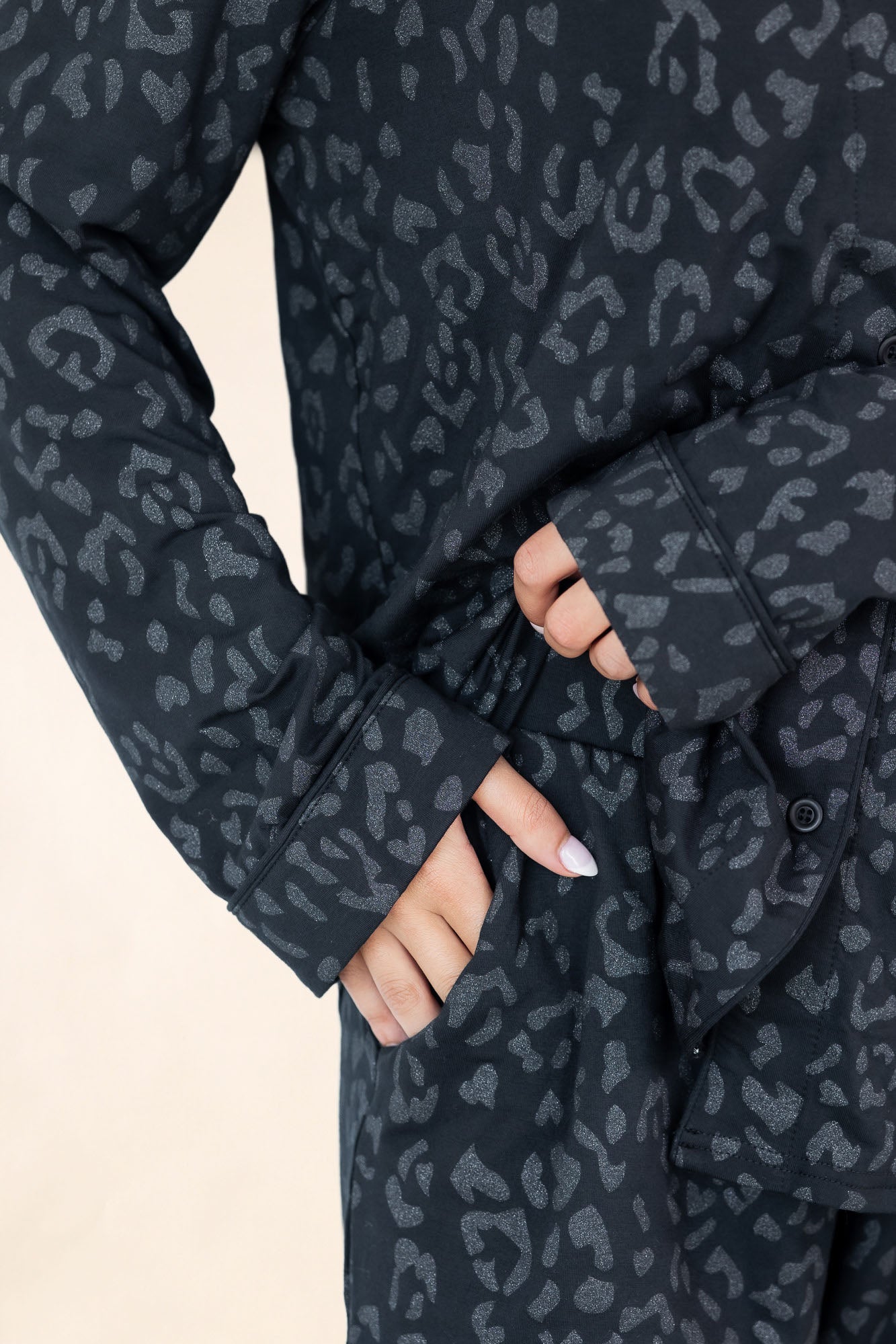 Dark gray leopard print pajama set with a beige background