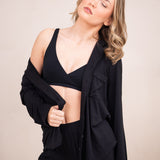 Woman modeling black cross front bralette and black pajama