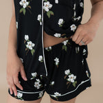 Woman modeling Women’s Short Sleeve Pajama Set in Big Midnight Magnolia. Close up on waistband of shorts.