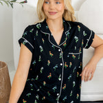 Model sitting on floor wearing Women's Short Sleeve Cropped Pajama Set in Midnight Wildflower print against a white couch
---PJ 4