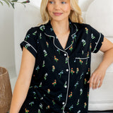 Model sitting on floor wearing Women's Short Sleeve Cropped Pajama Set in Midnight Wildflower print against a white couch
---PJ 4