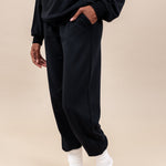 Woman wearing Women's Jogger Pants in Midnight color and a similar color Hoodie on a beige background
::: Model is 5'9" wearing size S ///