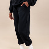 Woman wearing Women's Jogger Pants in Midnight color and a similar color Hoodie on a beige background
::: Model is 5'9" wearing size S ///