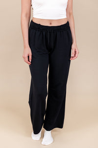 Modal wearing Women's Sweatpants in Midnight color under white flex bra tank on a beige background