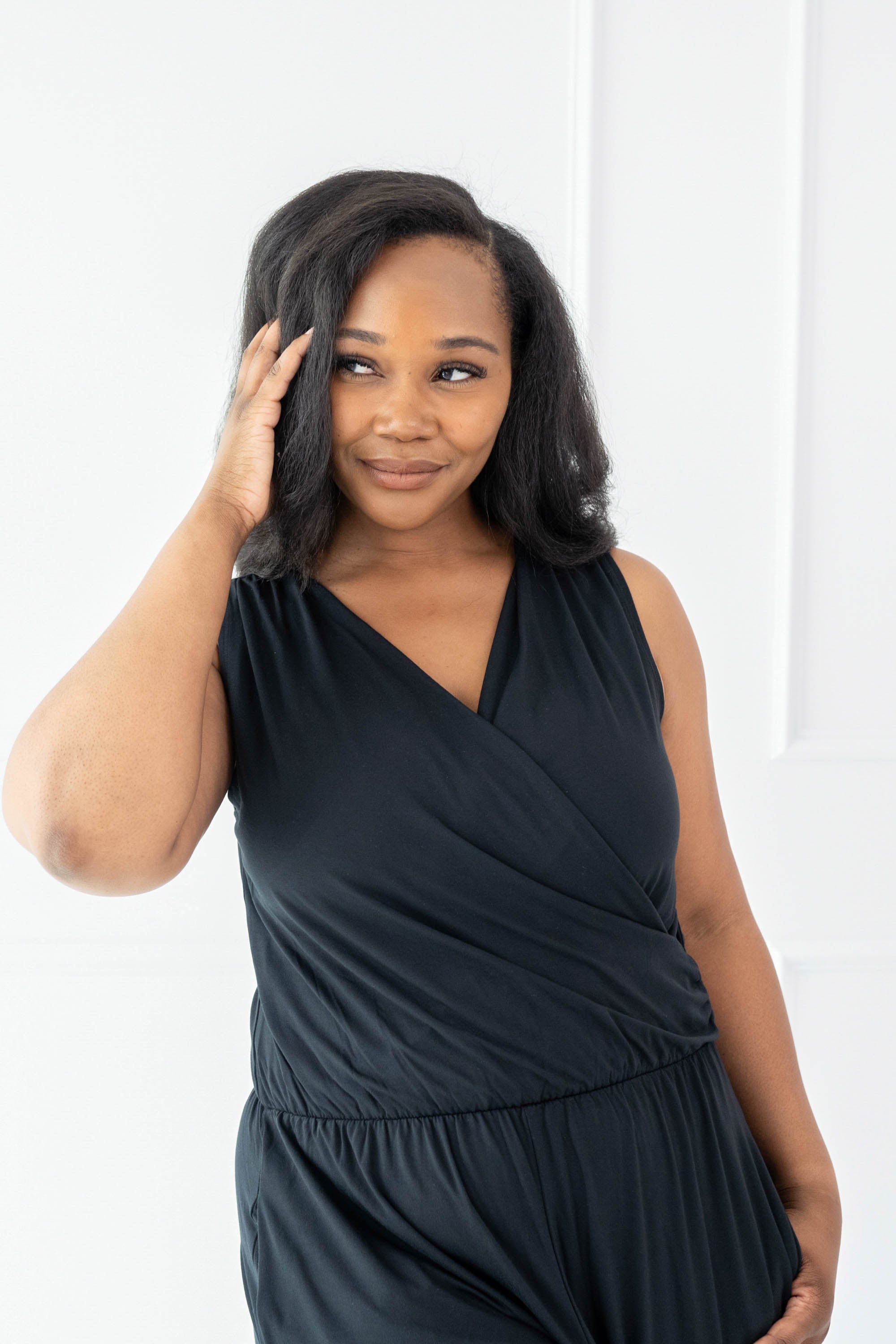 Model wearing the Women's Jumpsuit in Midnight with one hand in hair