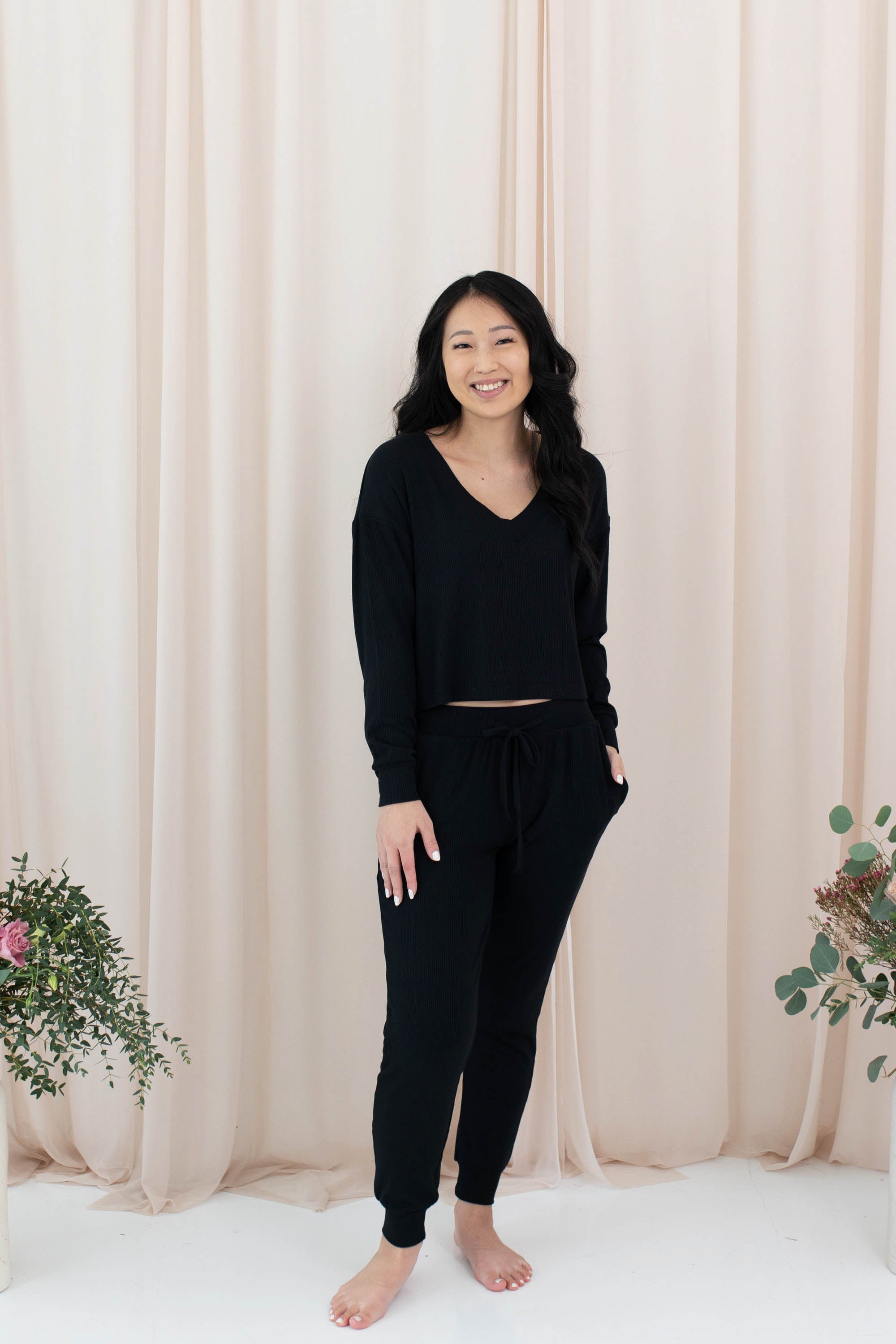 Female model wearing the Women's Ribbed Long Sleeve Crop Top in Midnight paired with Midnight Joggers Pants