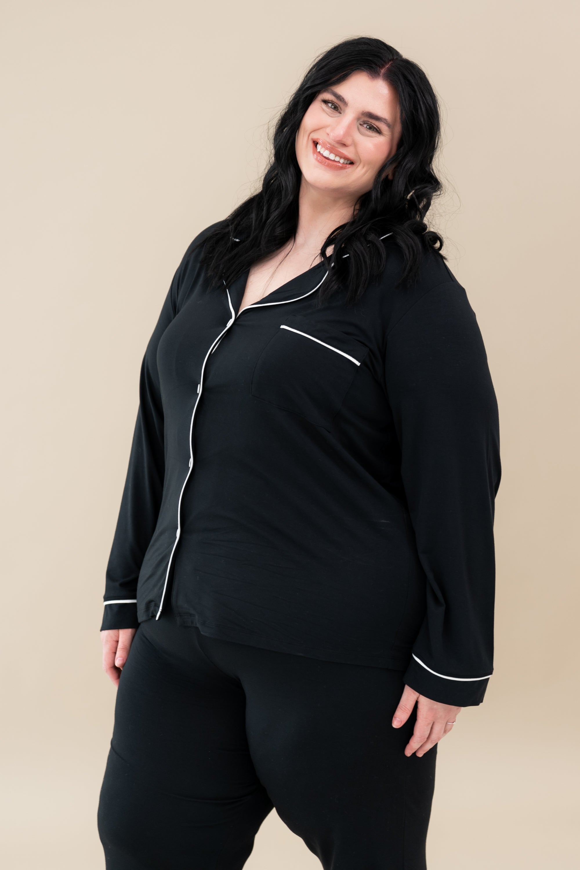 Female model wearing Kyte Baby's Women's Long Sleeve Pajama Set in Midnight with Cloud Trim