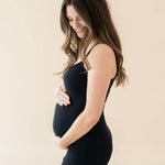 Expectant mother cradling her baby bump wearing the Women's Ribbed Cami Dress in Midnight