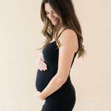 Expectant mother cradling her baby bump wearing the Women's Ribbed Cami Dress in Midnight