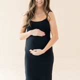 Expectant mother cradling her baby bump wearing the Women's Ribbed Cami Dress in Midnight